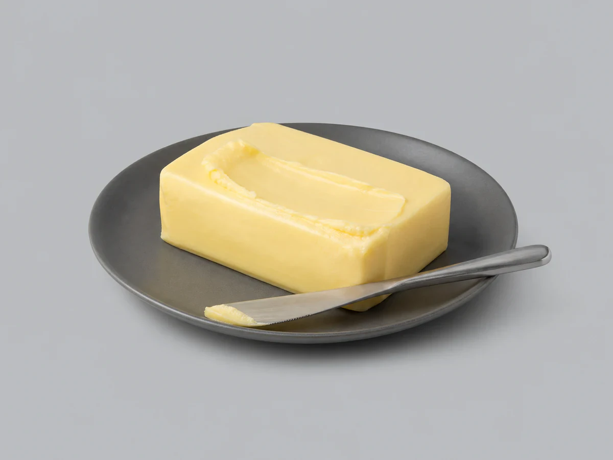Pat of yellow margarine on a dish, firm yet spreadable